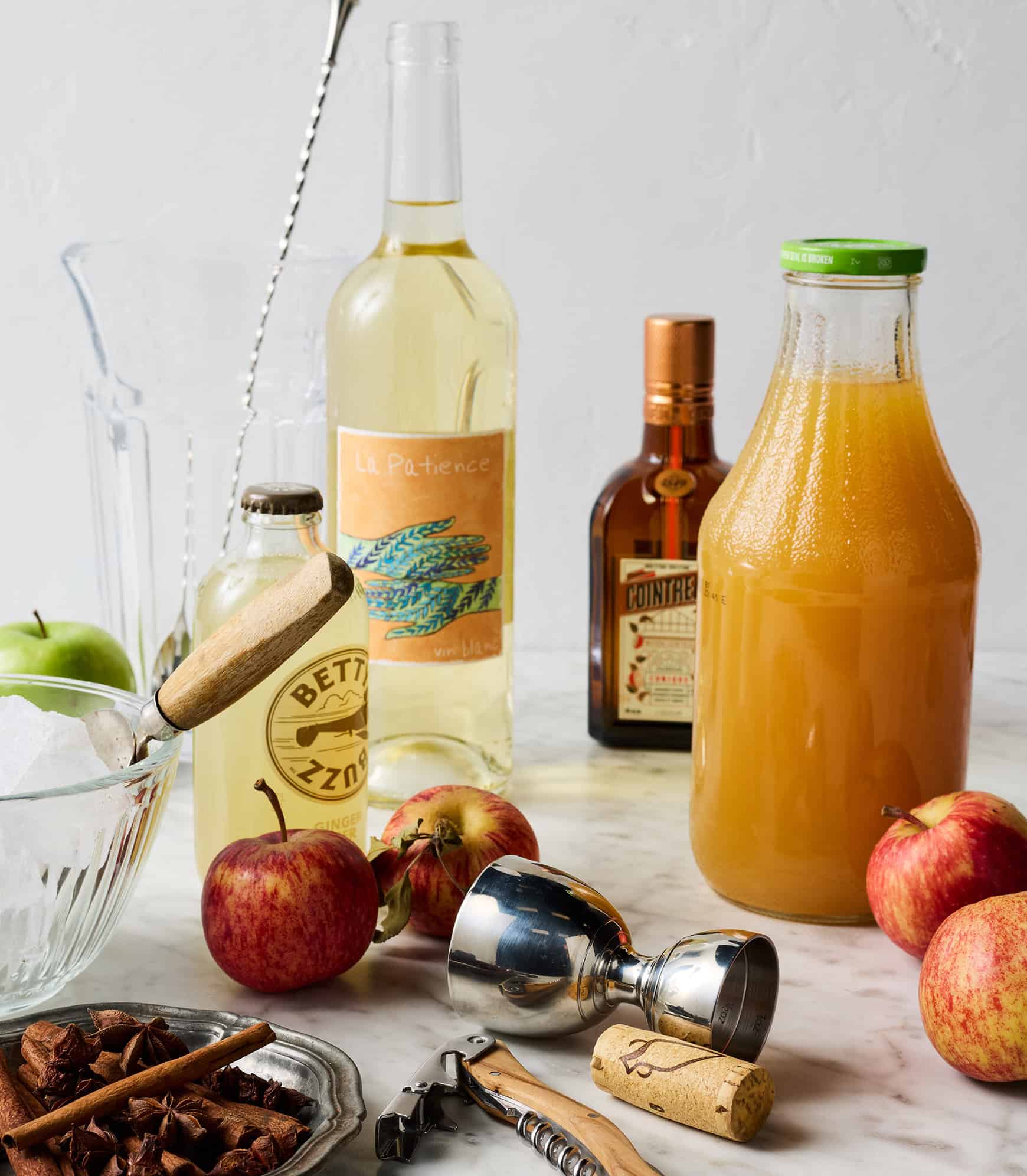 Recipe ingredients - white wine, apple cider, Cointreau, ginger beer, apples, cinnamon sticks, and star anise