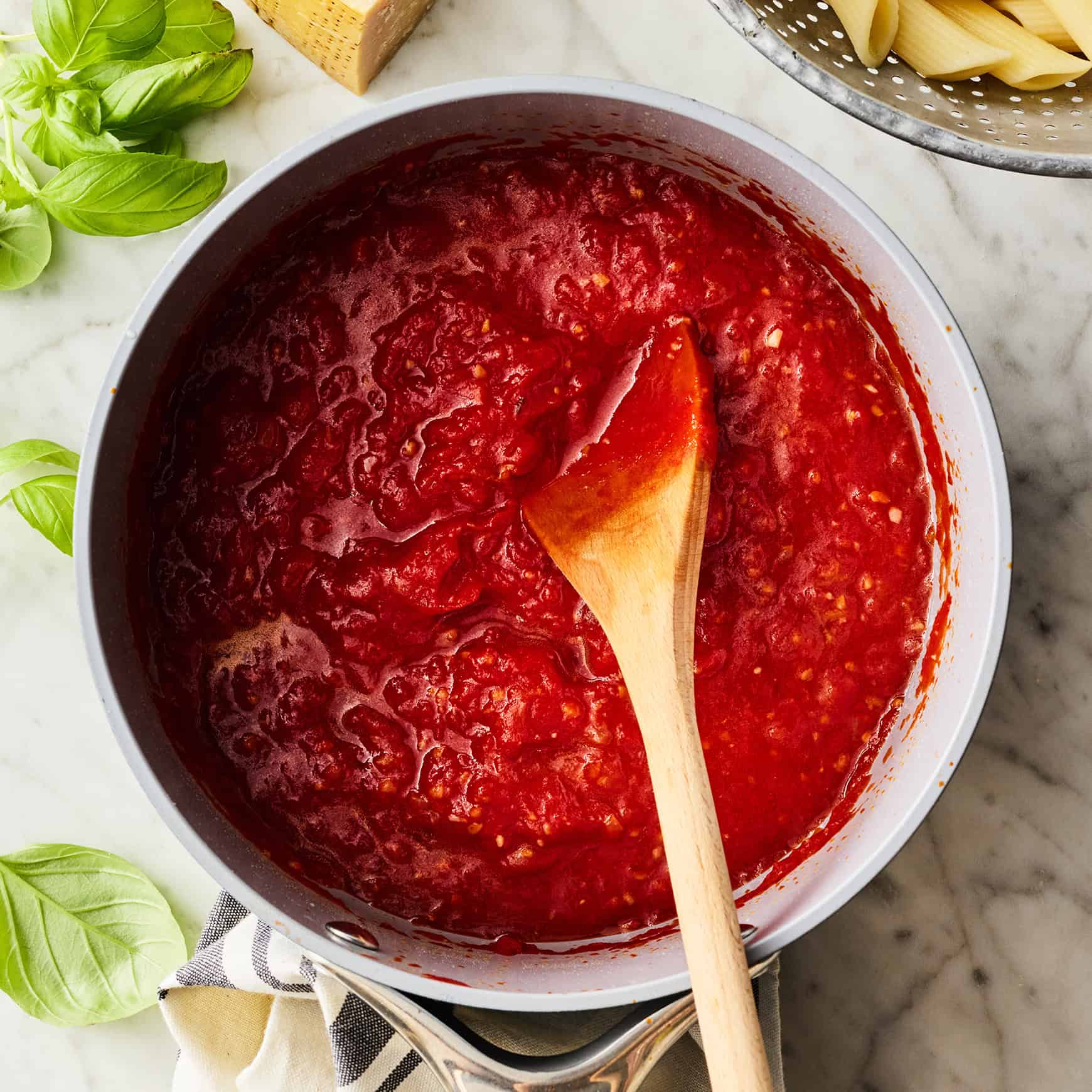 Arrabbiata sauce in saucepan with wooden spoon