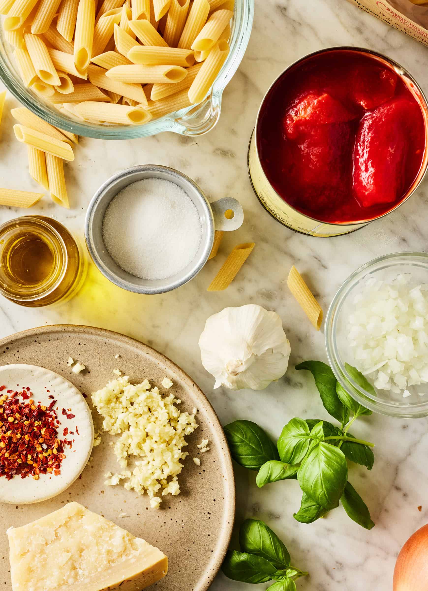 Recipe ingredients - San Marzano tomatoes, garlic, onion, olive oil, salt, and red pepper flakes with penne pasta and Parmesan cheese