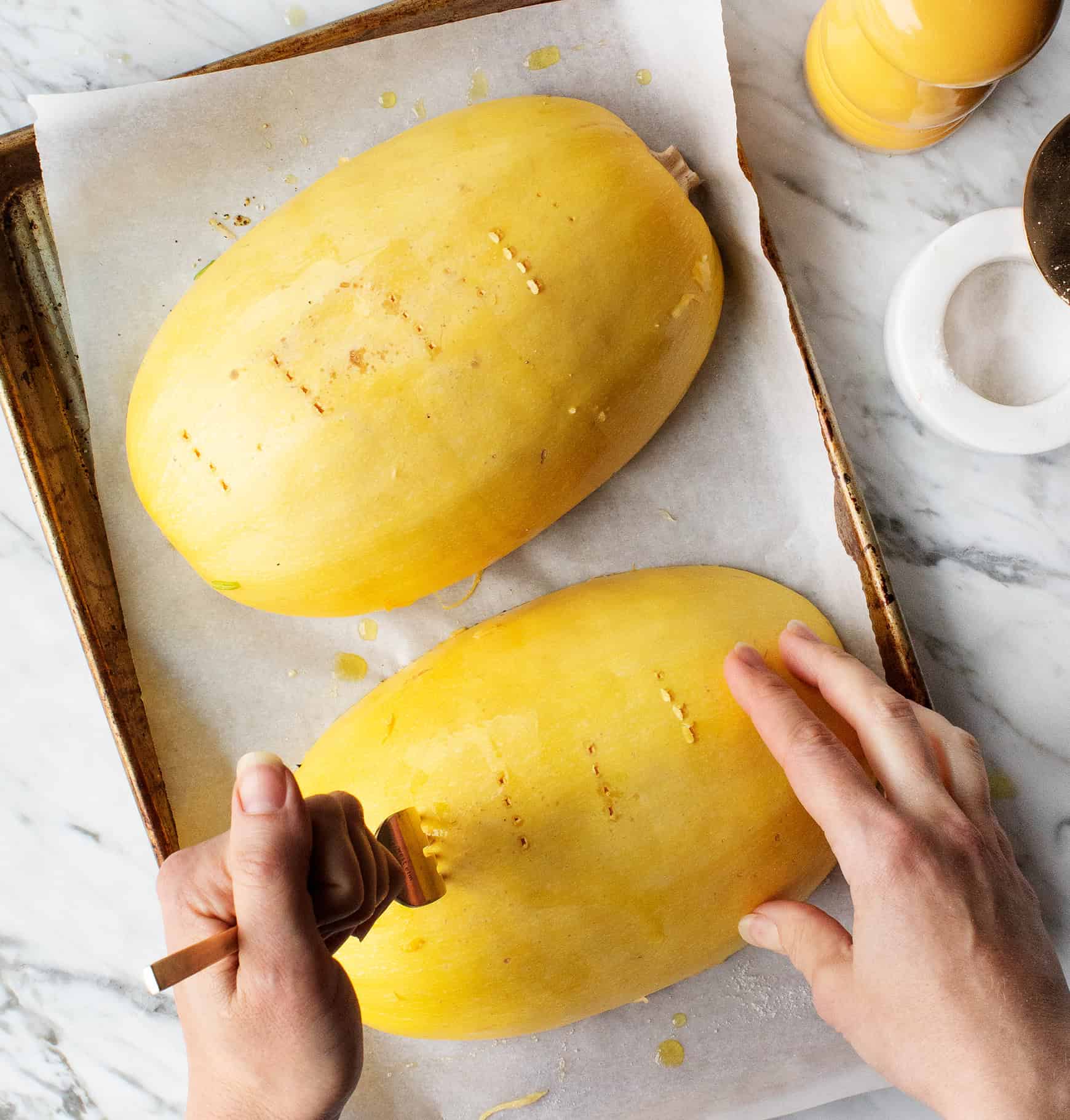 hands poking holes in the spaghetti squash