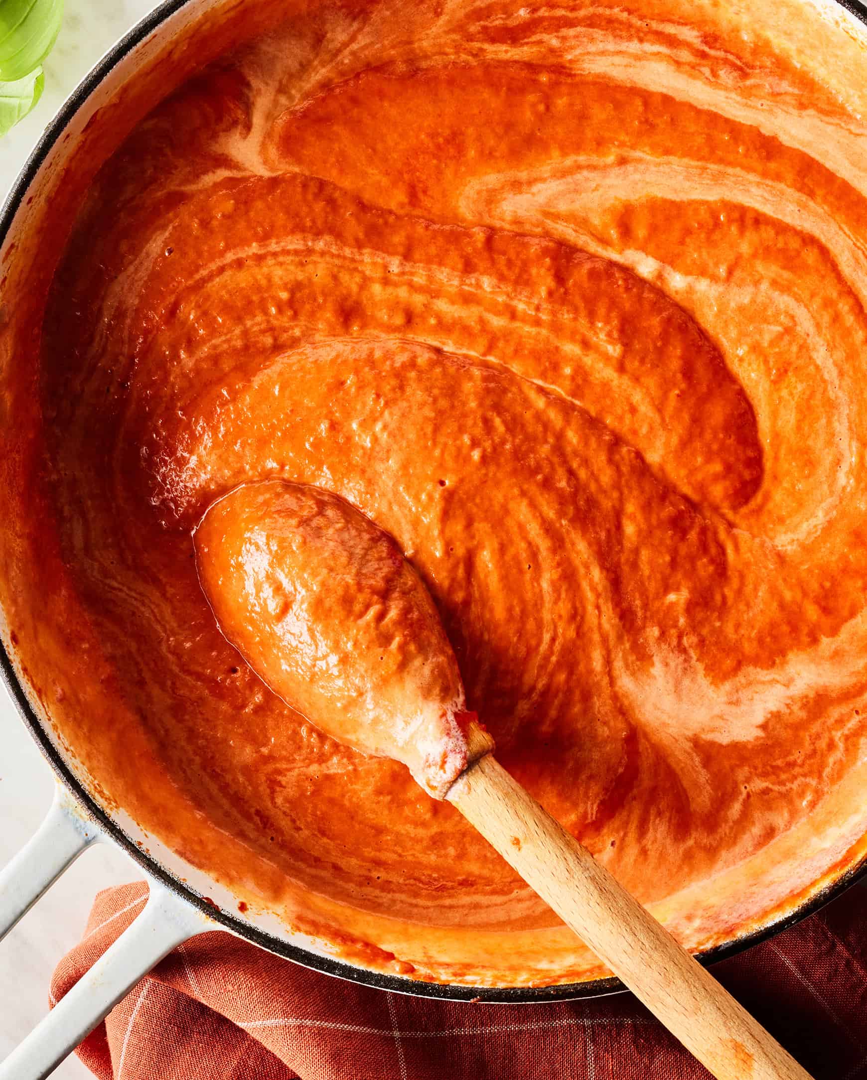Stirring cream into tomato sauce to make vodka sauce