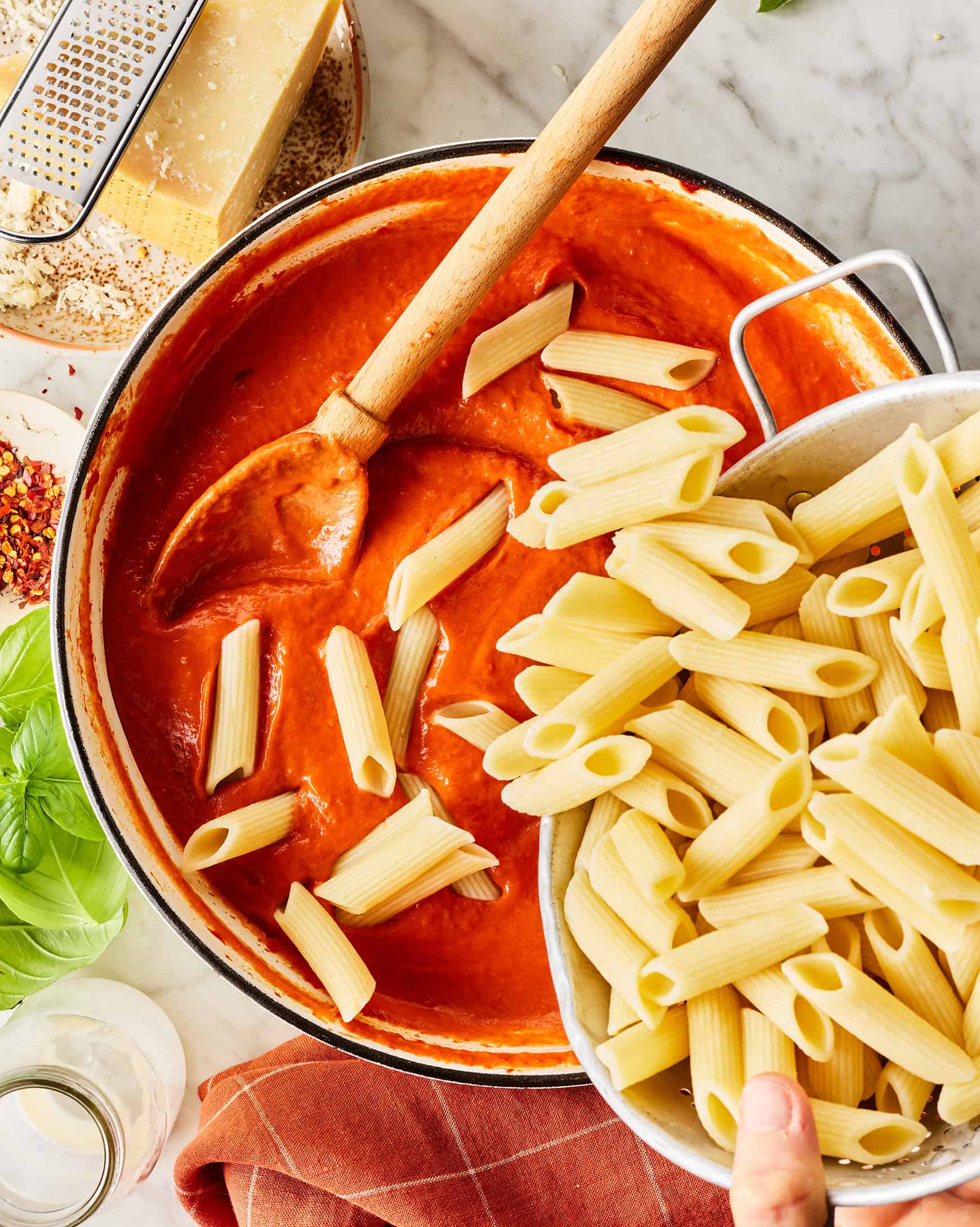 Adding cooked penne to vodka sauce