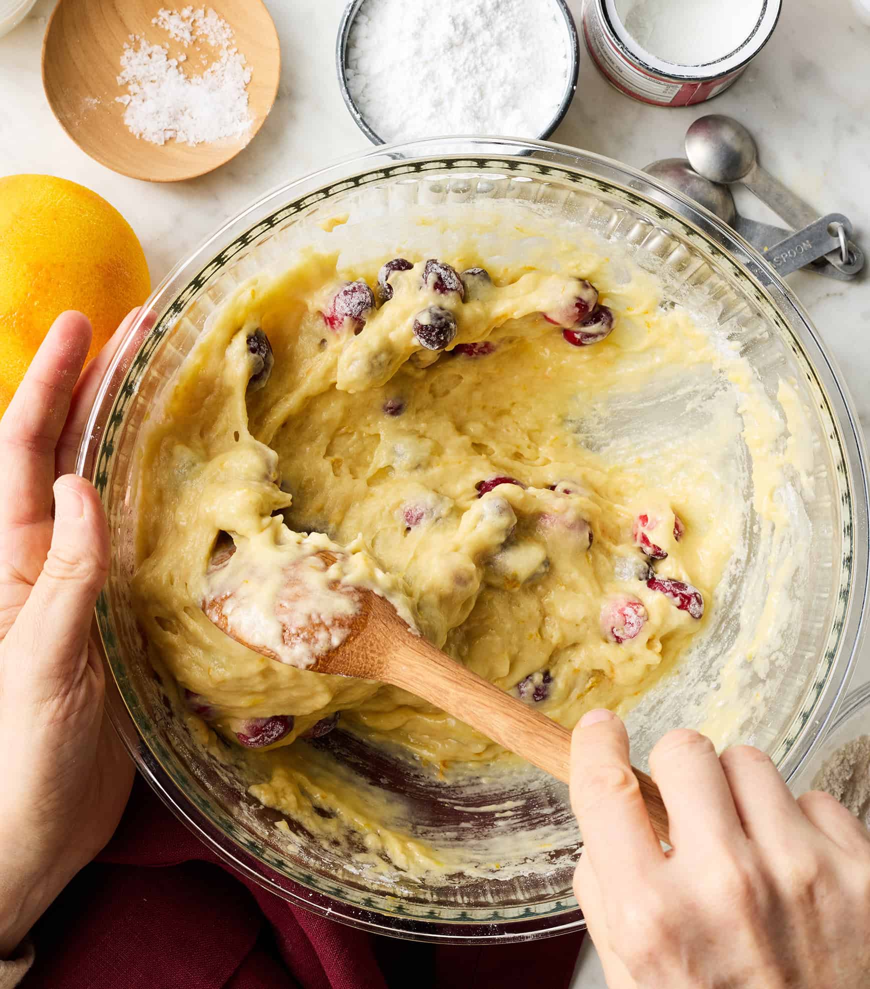 Mixing cranberry orange bread batter in glass bowl