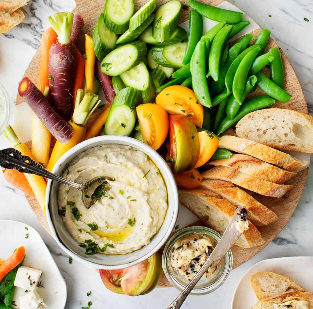 Crudité platter with fresh veggies, baguette, and white bean dip