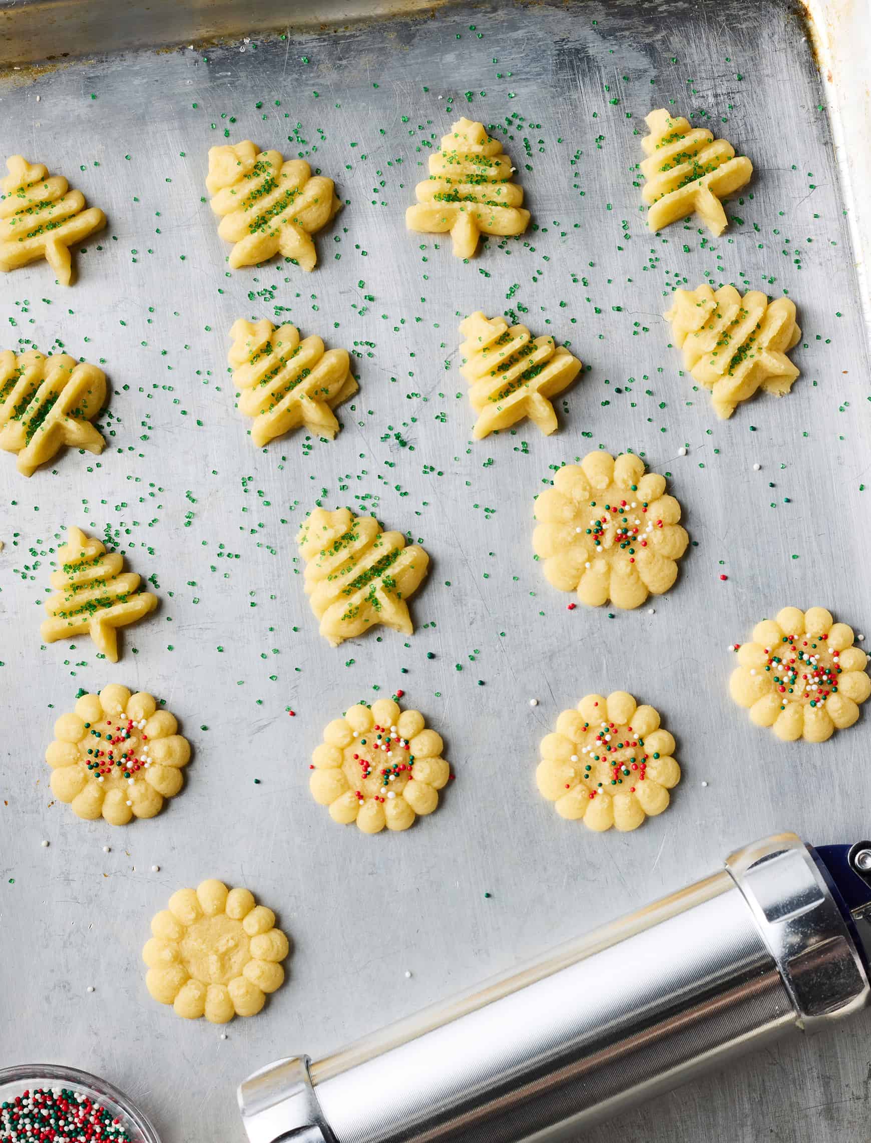 Unbaked cookies on baking sheet with red and green sprinkles