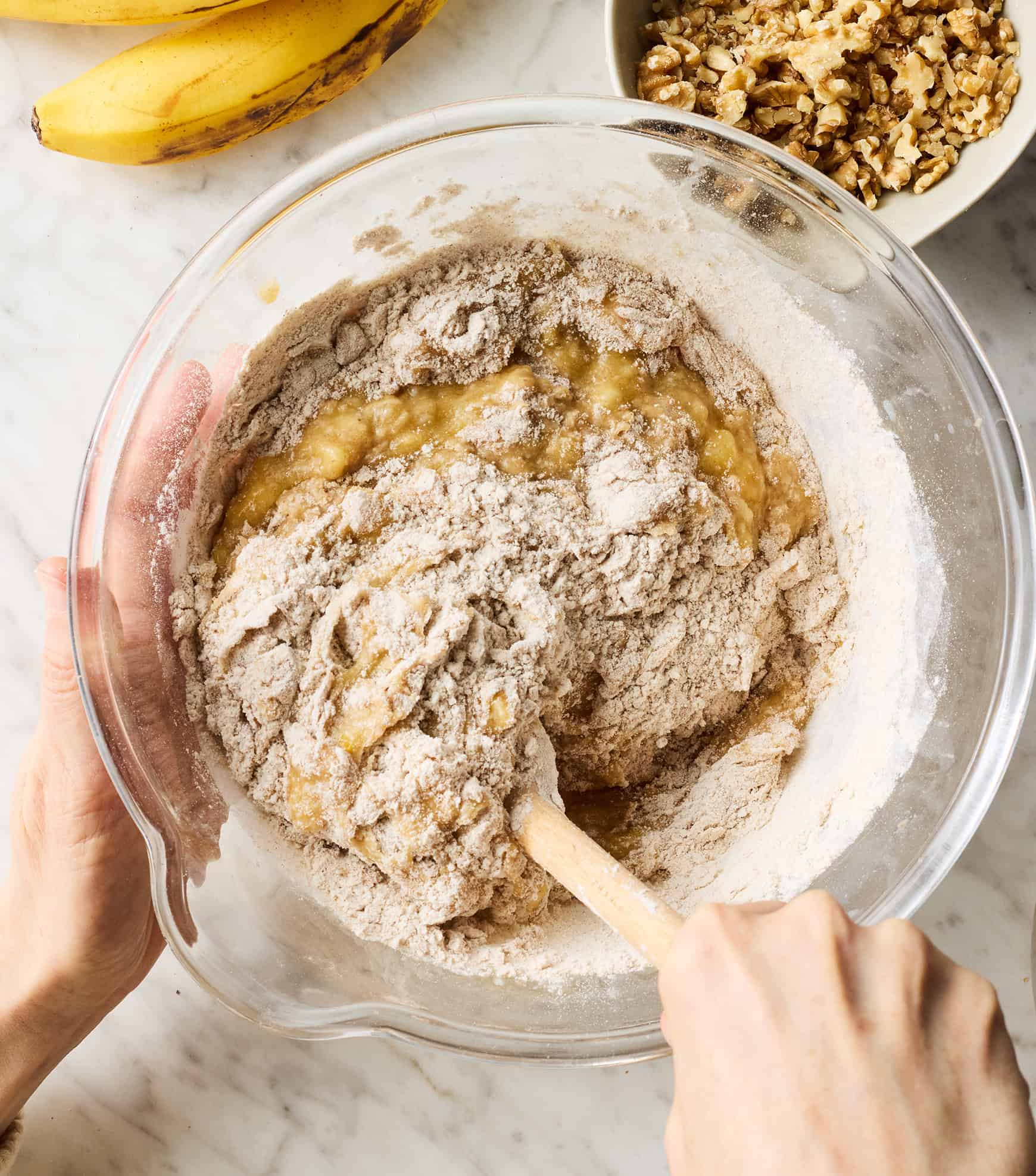 Combining wet and dry ingredients in glass mixing bowl